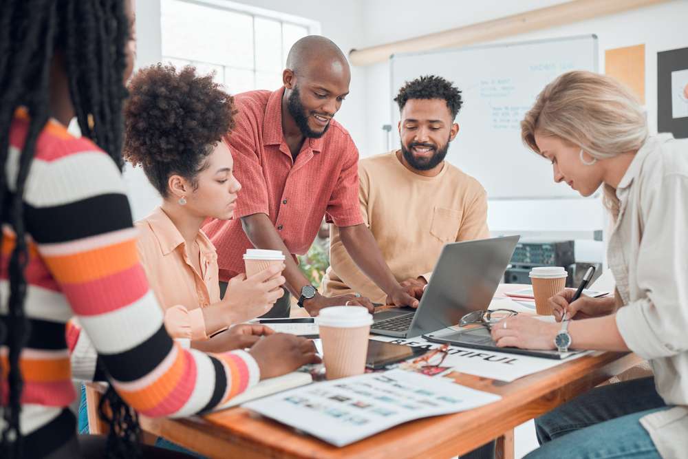 Meeting, startup and business people on laptop for discussion, planning and ideas for group project. Teamwork, creative company and men and women for collaboration, conversation and online feedback
